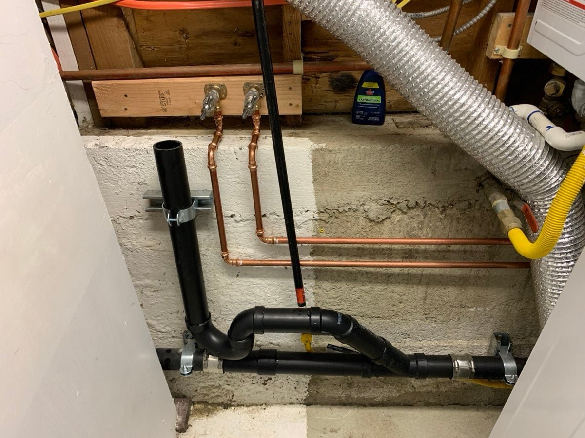 New copper supply lines with laundry valves along a basement wall