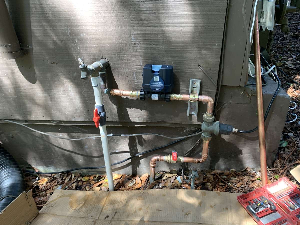 Smart shut-off installed on a copper water main at a house exterior